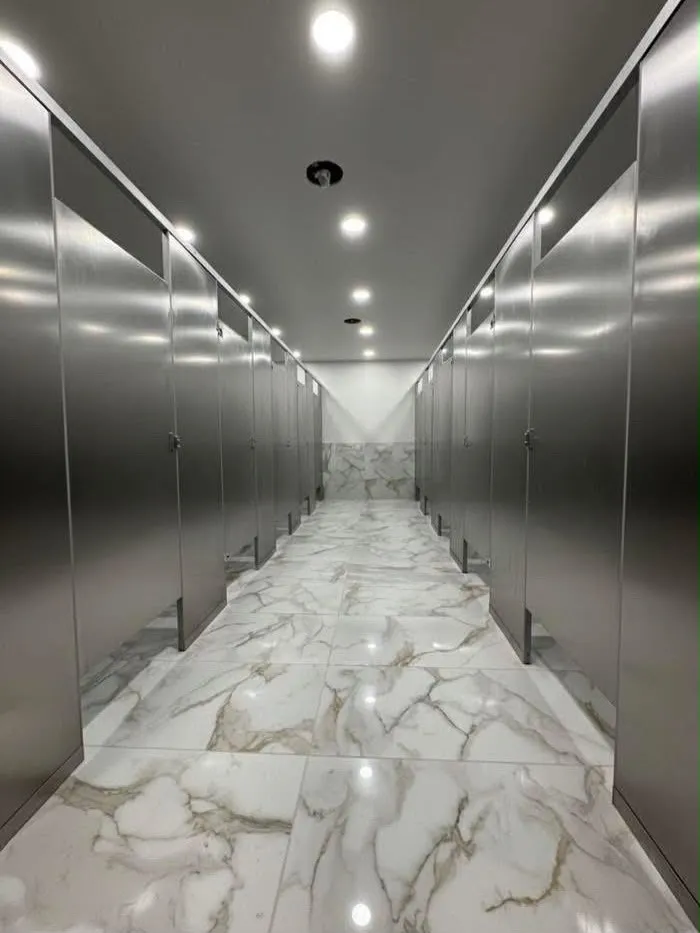 Mamparas de acero inoxidable instaladas en corredor sanitario